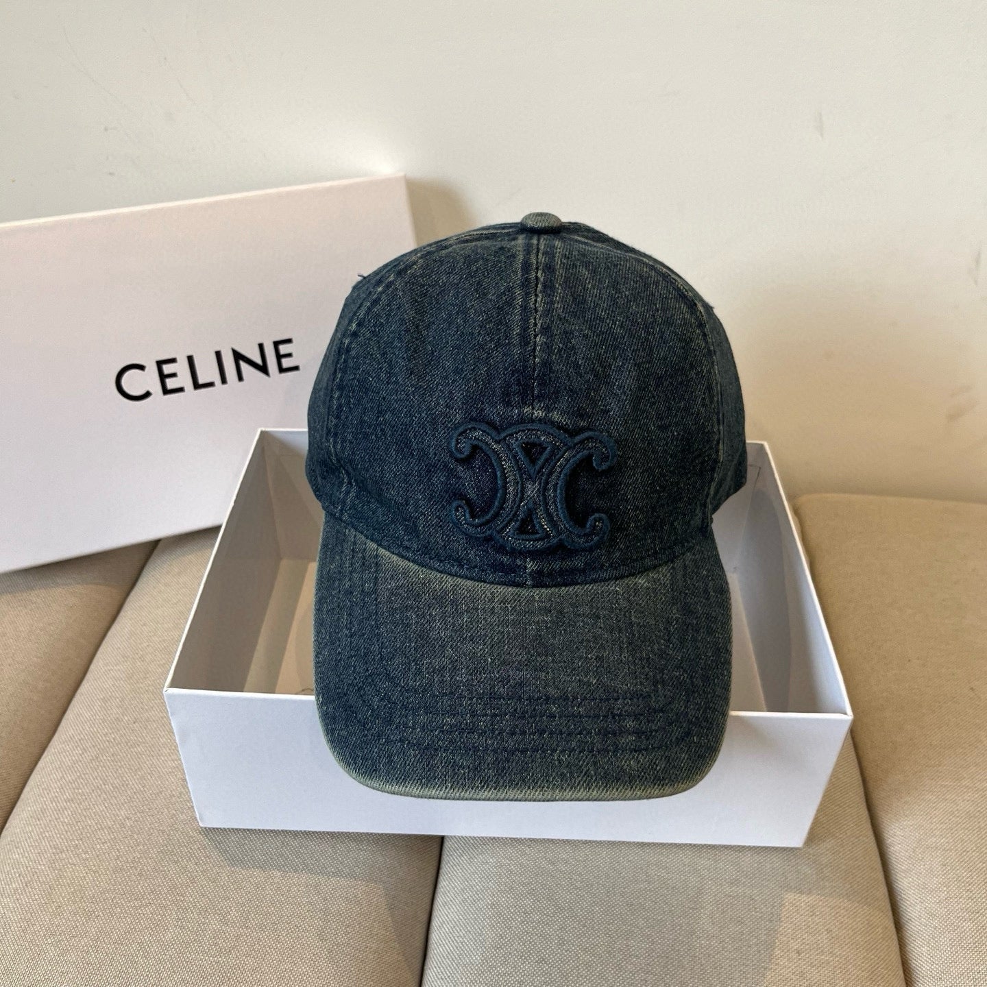 Washed blue denim cap with tonal emblem and gold buckle