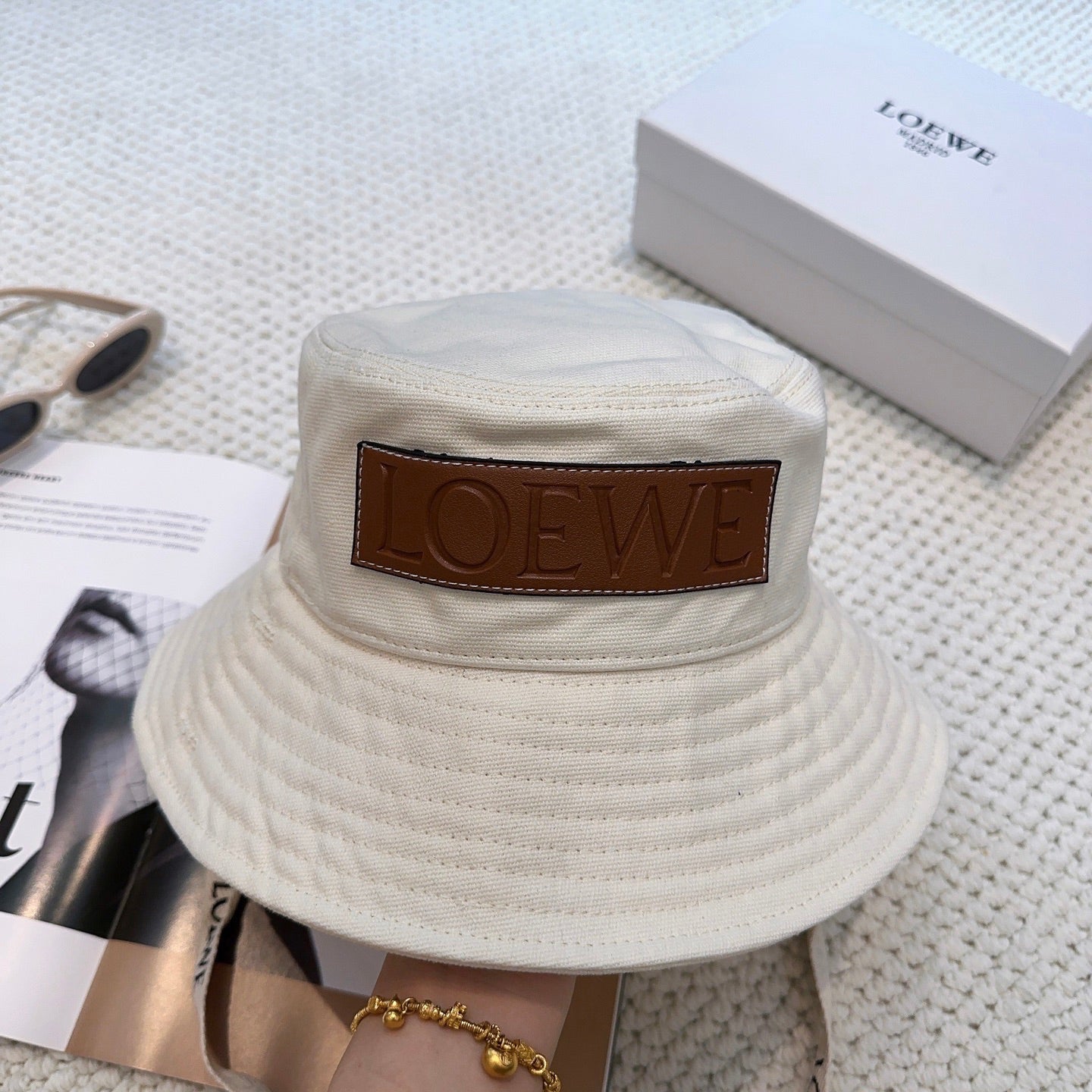 Soft canvas bucket hat with embossed leather logo patch and adjustable chin strap
