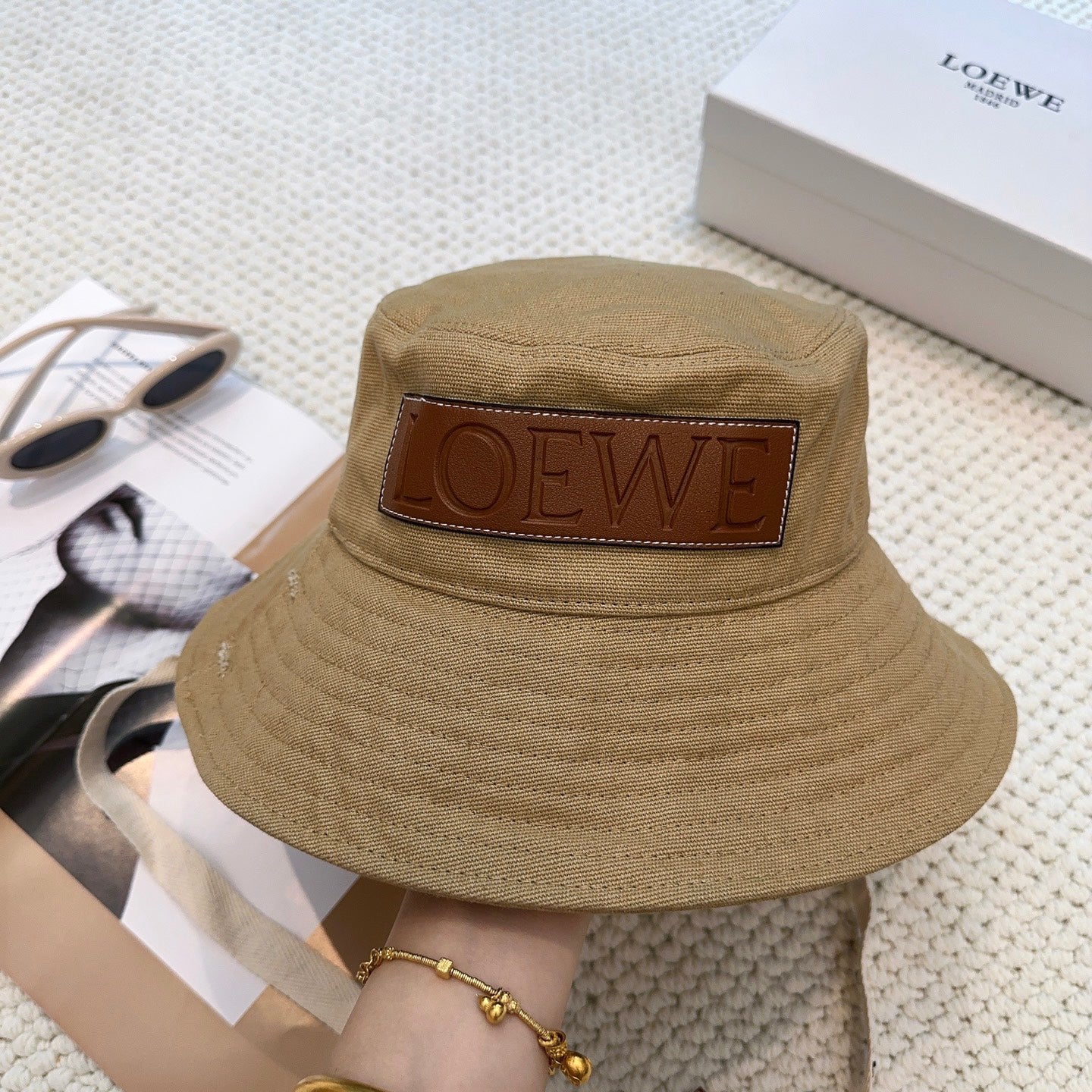 Soft canvas bucket hat with embossed leather logo patch and adjustable chin strap