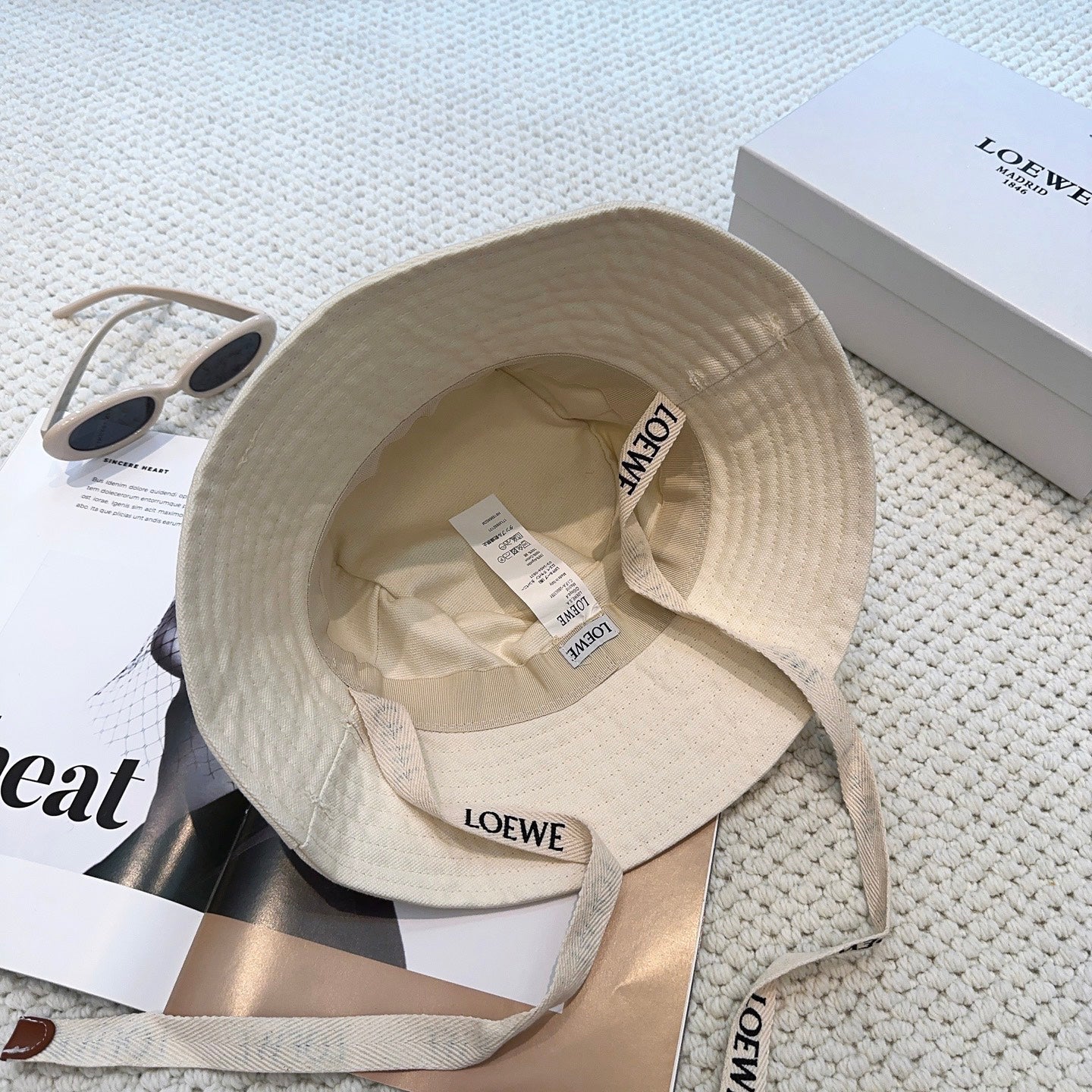 Soft canvas bucket hat with embossed leather logo patch and adjustable chin strap