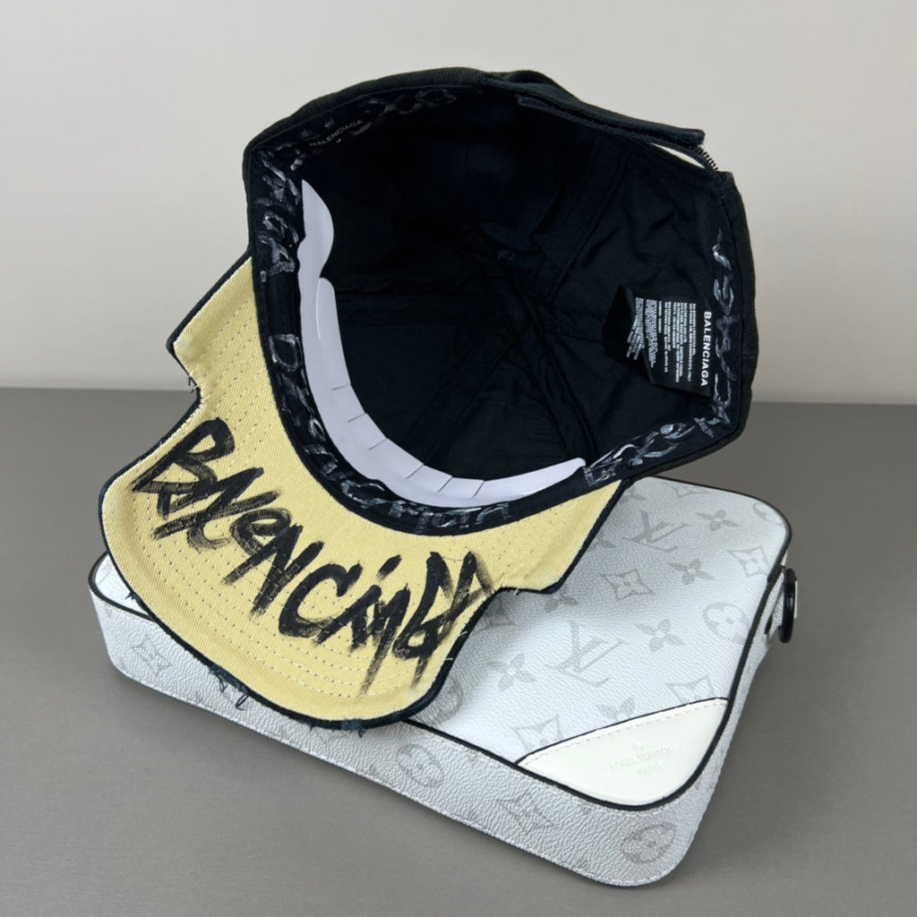 Black distressed cotton cap with contrast emblem and graffiti underbrim