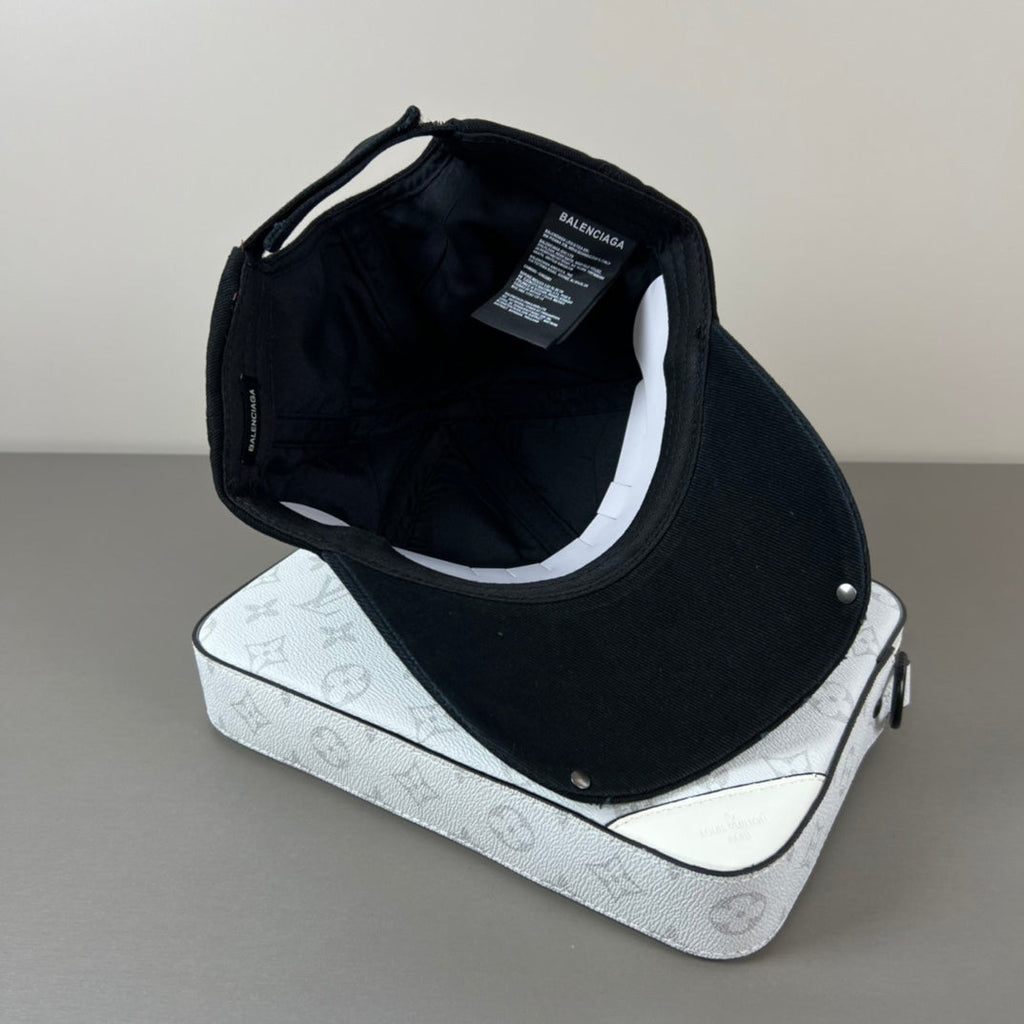 Black distressed cotton cap with metal graphic and glossy shield brim
