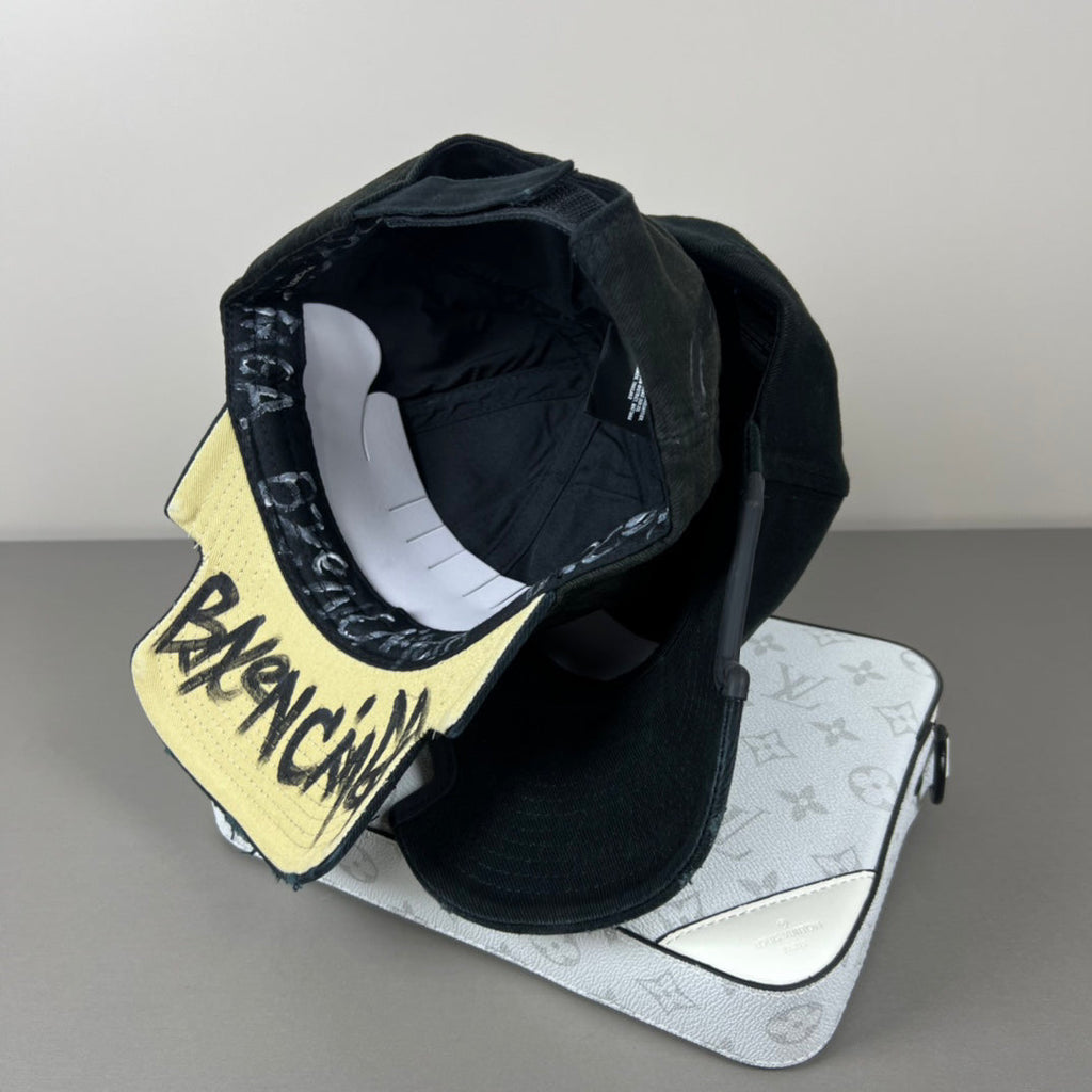 Black distressed cotton cap with contrast emblem and graffiti underbrim